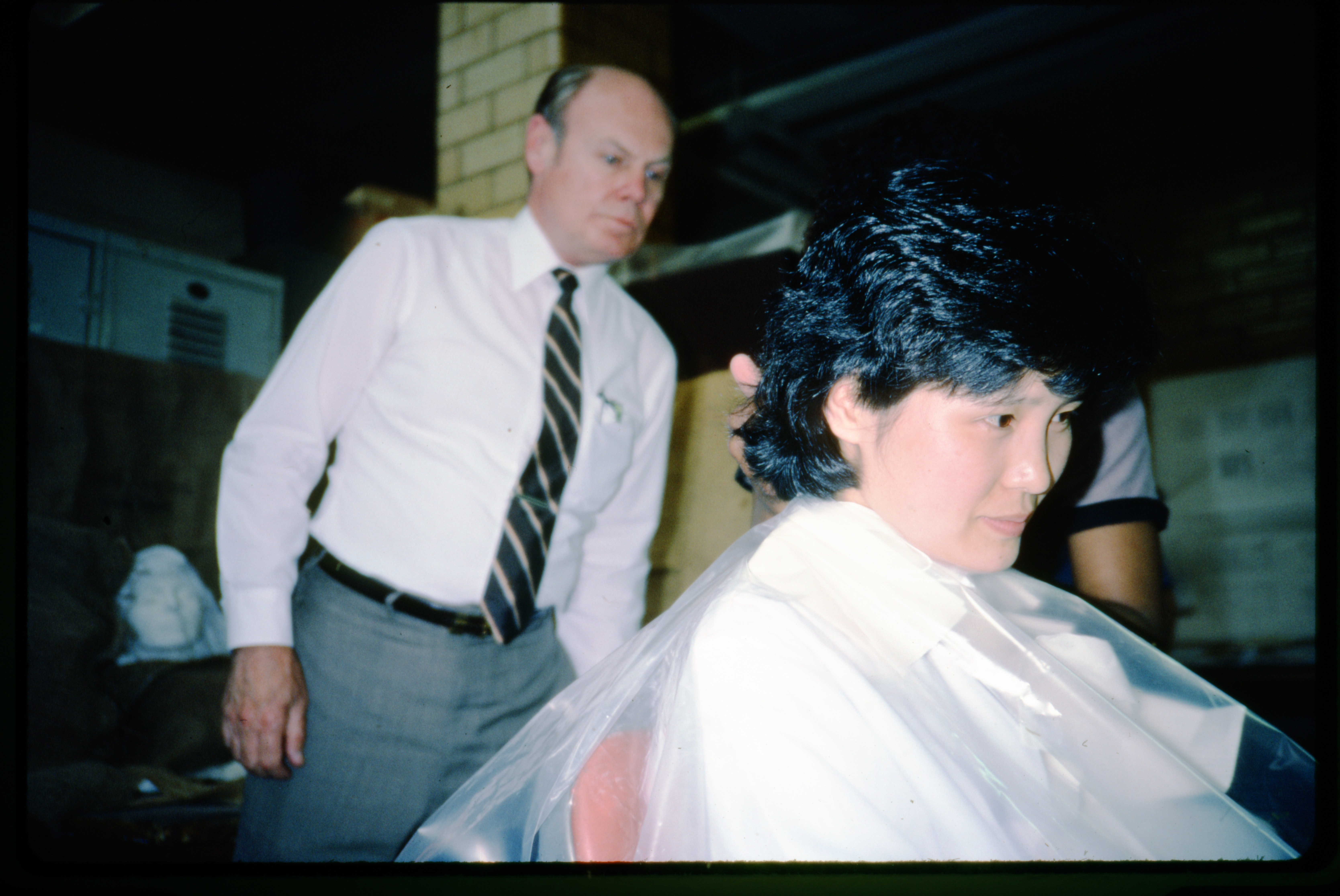 Model Chong-Hwa Lim sits to have a mold of her face made as manager Ralph Bauer looks on.